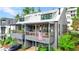Charming home with spacious decks, outdoor seating, string lights, and an American flag at 10862 Serenbe Ln, Chattahoochee Hills, GA 30268