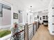 Bright hallway featuring hardwood floors, modern lighting, and sleek railings, offering an inviting passage between rooms at 10862 Serenbe Ln, Chattahoochee Hills, GA 30268