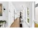 Light-filled hallway with white walls, modern light fixtures, and hardwood floors, creating an elegant and airy atmosphere at 10862 Serenbe Ln, Chattahoochee Hills, GA 30268