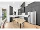 Modern kitchen featuring dark cabinets, stainless steel appliances, a butcher block island, and hardwood floors at 10862 Serenbe Ln, Chattahoochee Hills, GA 30268