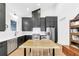 Modern kitchen featuring dark cabinets, stainless steel appliances, a butcher block island, and hardwood floors at 10862 Serenbe Ln, Chattahoochee Hills, GA 30268