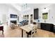 Open-concept living room with high ceilings, hardwood floors, fireplace, and modern kitchen with dark cabinets at 10862 Serenbe Ln, Chattahoochee Hills, GA 30268