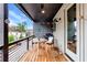 Relaxing covered porch features wood flooring, string lights and views of the surrounding neighborhood at 10862 Serenbe Ln, Chattahoochee Hills, GA 30268