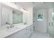 Modern bathroom featuring double sinks, sleek white cabinetry, and a glass shower at 1534 River Rock Trce, Woodstock, GA 30188