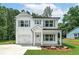 Charming two-story home with white siding, gray shutters, and well-manicured front yard at 1534 River Rock Trce, Woodstock, GA 30188