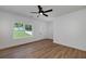 Bright living room featuring wood floors, ceiling fan, and view of the landscaped front yard at 1534 River Rock Trce, Woodstock, GA 30188
