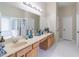 A bright main bathroom with double sink vanity, large mirror, and separate tub at 3906 Elm Trace Ct, Loganville, GA 30052