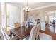 Stylish dining room with a wood table, upholstered chairs, and views into the living spaces at 3906 Elm Trace Ct, Loganville, GA 30052