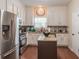 A kitchen with white cabinets, stainless steel appliances, granite counters, a center island, and hardwood floors at 3906 Elm Trace Ct, Loganville, GA 30052