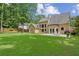 Expansive backyard with patio, lush lawn, and the house's back featuring large windows and outdoor seating at 4204 Woodfare Nw Ln, Kennesaw, GA 30152