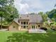 Rear exterior view of home featuring a spacious yard, patio with furniture and mature trees at 4204 Woodfare Nw Ln, Kennesaw, GA 30152