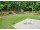 Expansive backyard with lush lawn, mature trees, waterfall feature, shed and patio seating at 4204 Woodfare Nw Ln, Kennesaw, GA 30152
