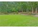 Large, manicured backyard with lush greenery, mature trees, a charming shed, and well-placed landscaping at 4204 Woodfare Nw Ln, Kennesaw, GA 30152