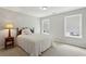 Cozy bedroom featuring neutral carpet, a bed, and dual windows for natural light at 4204 Woodfare Nw Ln, Kennesaw, GA 30152