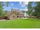 View of the back of the house with a well-manicured lawn, a patio area, and ample backyard space at 4204 Woodfare Nw Ln, Kennesaw, GA 30152