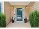 Close-up of the front door and porch area featuring flower pots and sconce lighting at 4204 Woodfare Nw Ln, Kennesaw, GA 30152