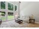 Bright living room with large windows, comfortable seating, and view of landscaped yard at 4204 Woodfare Nw Ln, Kennesaw, GA 30152
