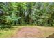 Exterior view of a home's backyard featuring a dirt mound and many trees at 1538 Belva Ave, Decatur, GA 30032