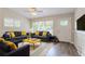 Bright living room featuring hardwood floors, large windows, and stylish decor at 1538 Belva Ave, Decatur, GA 30032