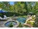 Aerial view showcasing a custom pool with spa, lush landscaping, and inviting patio seating at 1589 Trentwood Ne Pl, Brookhaven, GA 30319