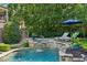 Sparkling pool with stone accents and a waterfall feature creates a serene backyard oasis at 1589 Trentwood Ne Pl, Brookhaven, GA 30319