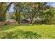 Large backyard with healthy green grass and some trees providing shade plus a wooden fence line at 2728 Mcafee Rd, Decatur, GA 30032