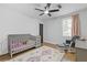 Bedroom with a crib, soft rug, and a comfortable chair near the window at 2728 Mcafee Rd, Decatur, GA 30032