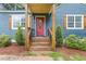 Welcoming red front door of a charming blue home, complemented by neat landscaping at 2728 Mcafee Rd, Decatur, GA 30032
