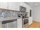 Modern kitchen with stainless appliances, granite countertops, and stylish tile backsplash at 2728 Mcafee Rd, Decatur, GA 30032