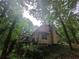 Exterior angle shows elevated back deck and wooded lot surrounding a cozy home at 33 Powder Dr, Dallas, GA 30157