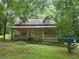Charming two-story home with a covered front porch, landscaped yard, and mature trees providing shade at 33 Powder Dr, Dallas, GA 30157