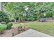 Well-maintained backyard featuring lush green lawn, mature trees, and outdoor seating area at 1635 Lake Heights Cir, Dacula, GA 30019
