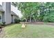 Backyard featuring green grass, mature trees, wooden fence, and a cornhole game at 1635 Lake Heights Cir, Dacula, GA 30019