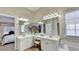 Elegant bathroom features dual sinks, vanity, white cabinetry, and decorative wallpaper at 1635 Lake Heights Cir, Dacula, GA 30019