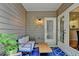 Inviting covered patio with comfortable seating, plants, and view to the house interior at 1635 Lake Heights Cir, Dacula, GA 30019