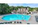 Community pool and clubhouse with chairs and tables surrounded by trees at 1635 Lake Heights Cir, Dacula, GA 30019