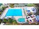 Aerial view of a pristine community pool area featuring a water park, lounge chairs, and shaded seating at 1635 Lake Heights Cir, Dacula, GA 30019