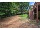 Explore the expansive backyard with lush trees and a staircase leading to the deck above, blending nature and design at 223 Sterling Brook Ln, Canton, GA 30114