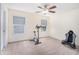 A bright bedroom with a ceiling fan, exercise bike, and neutral-toned carpet at 223 Sterling Brook Ln, Canton, GA 30114
