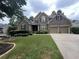 Charming brick home featuring a well-manicured lawn and a two-car garage at 223 Sterling Brook Ln, Canton, GA 30114