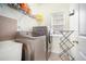 Dedicated laundry room with modern washer, dryer, and storage shelves at 223 Sterling Brook Ln, Canton, GA 30114