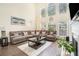 Bright living room featuring a large sectional sofa and tall windows providing natural light at 223 Sterling Brook Ln, Canton, GA 30114