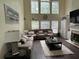Bright living room featuring a large sectional sofa, fireplace and tall windows providing natural light at 223 Sterling Brook Ln, Canton, GA 30114