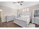 Bright main bedroom features a ceiling fan, hardwood floors, and matching dresser and nightstands at 223 Sterling Brook Ln, Canton, GA 30114