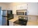 Efficient kitchen featuring stainless steel appliances and white cabinets at 475 Mount Vernon Ne Hwy # C-220, Sandy Springs, GA 30328