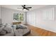 Airy bedroom featuring a queen bed, ceiling fan, wood floors, and a large window at 4908 Mill Brook Dr, Atlanta, GA 30338