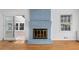 Close up of living room fireplace with blue painted bricks and decorative gold-trimmed door at 4908 Mill Brook Dr, Atlanta, GA 30338