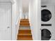Hallway stairs lead to the upper level with a stackable washer and dryer unit on the side at 4908 Mill Brook Dr, Atlanta, GA 30338