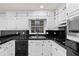 Modern kitchen featuring white cabinets, black countertops, a stainless steel sink, and appliances at 4908 Mill Brook Dr, Atlanta, GA 30338