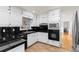 Kitchen with sleek black countertops, tile flooring, and white cabinetry, offering a clean look at 4908 Mill Brook Dr, Atlanta, GA 30338